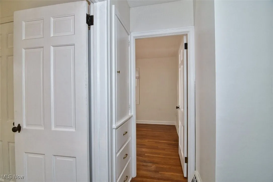 Corridor with dark wood-style floors and baseboards