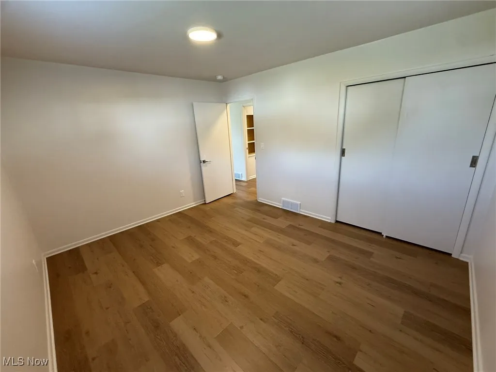 Unfurnished bedroom featuring wood finished floors and a closet