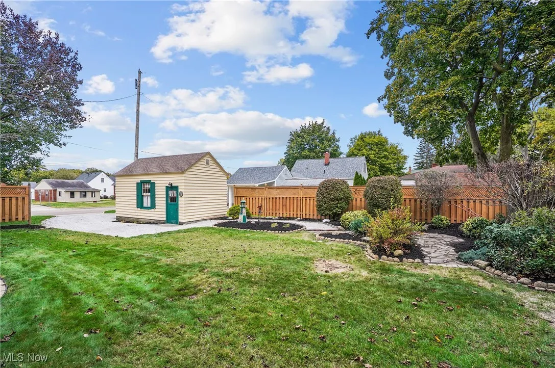 View of yard featuring a patio area, an outdoor structure, and a residential view