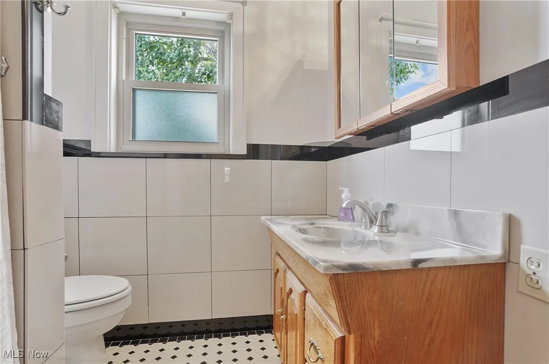 Bathroom featuring vanity, tile walls, and tile patterned flooring