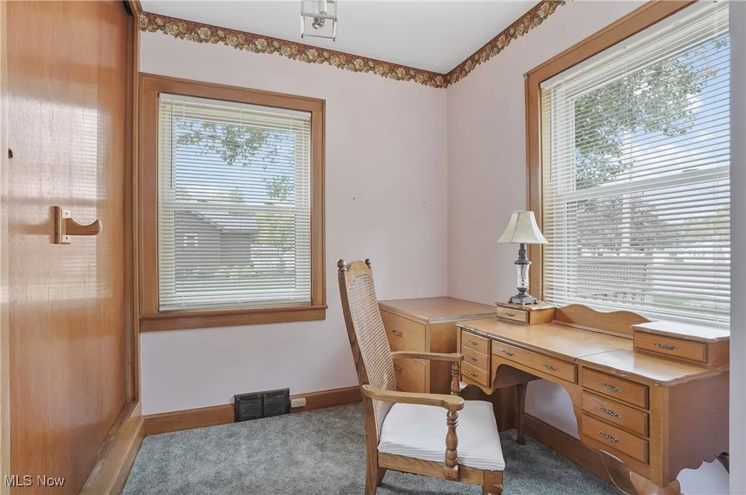 Office with baseboards and dark colored carpet