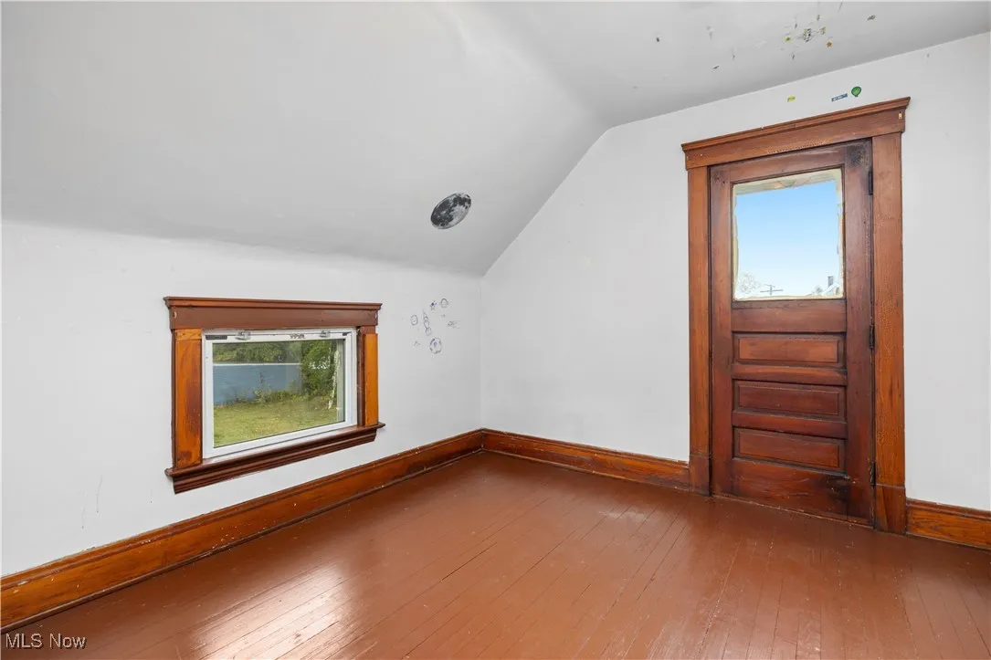 Bonus room featuring hardwood / wood-style floors and lofted ceiling