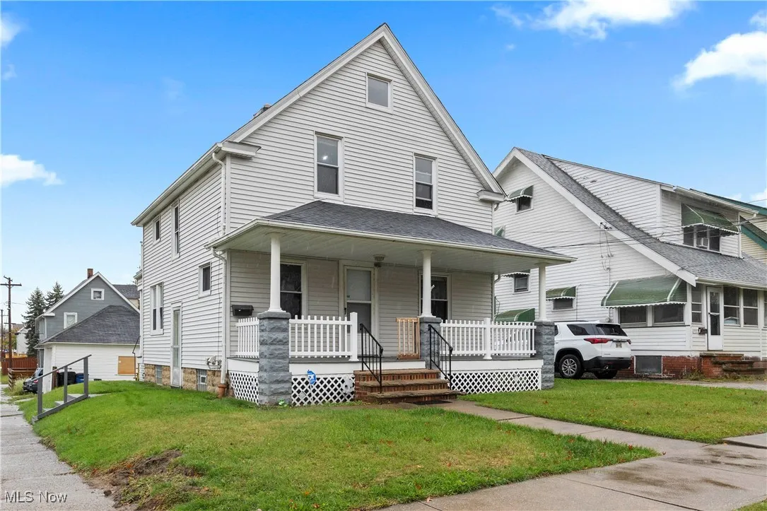 View of front of house with covered porch and a front yard