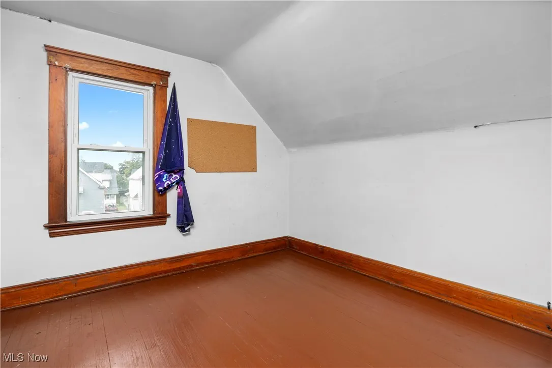 Bonus room with wood-type flooring and vaulted ceiling