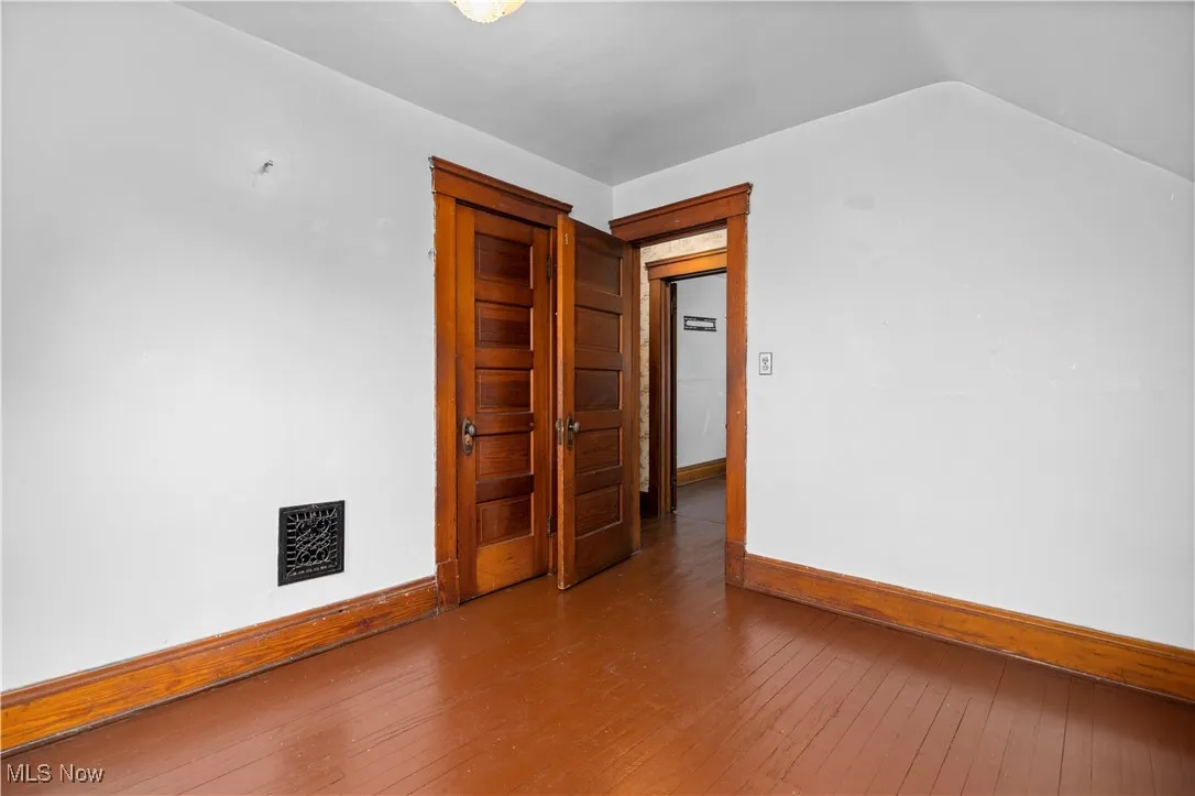 Empty room featuring hardwood / wood-style flooring and baseboards