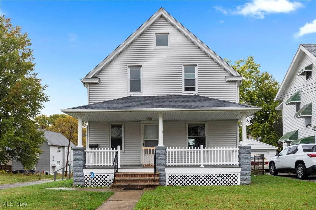 View of front facade featuring a porch, a front yard, and roof with shingles