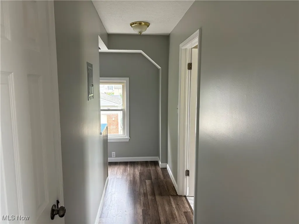 Hall with dark wood finished floors and a textured ceiling