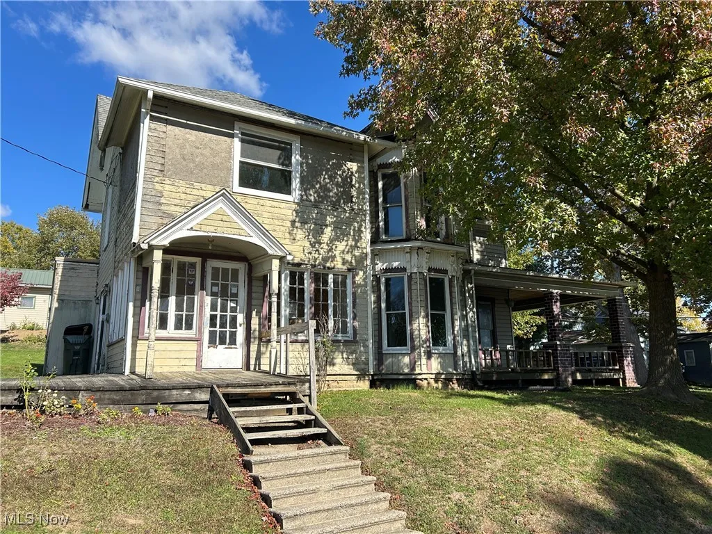 View of front of house featuring a deck and a front lawn