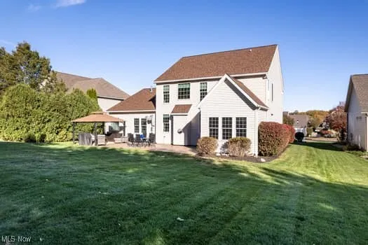 Rear view of house featuring a yard and a patio area