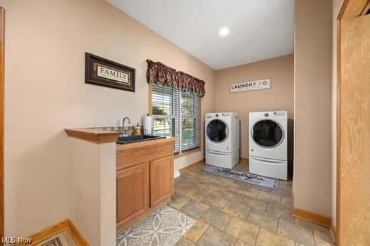Washroom with washer and clothes dryer and recessed lighting