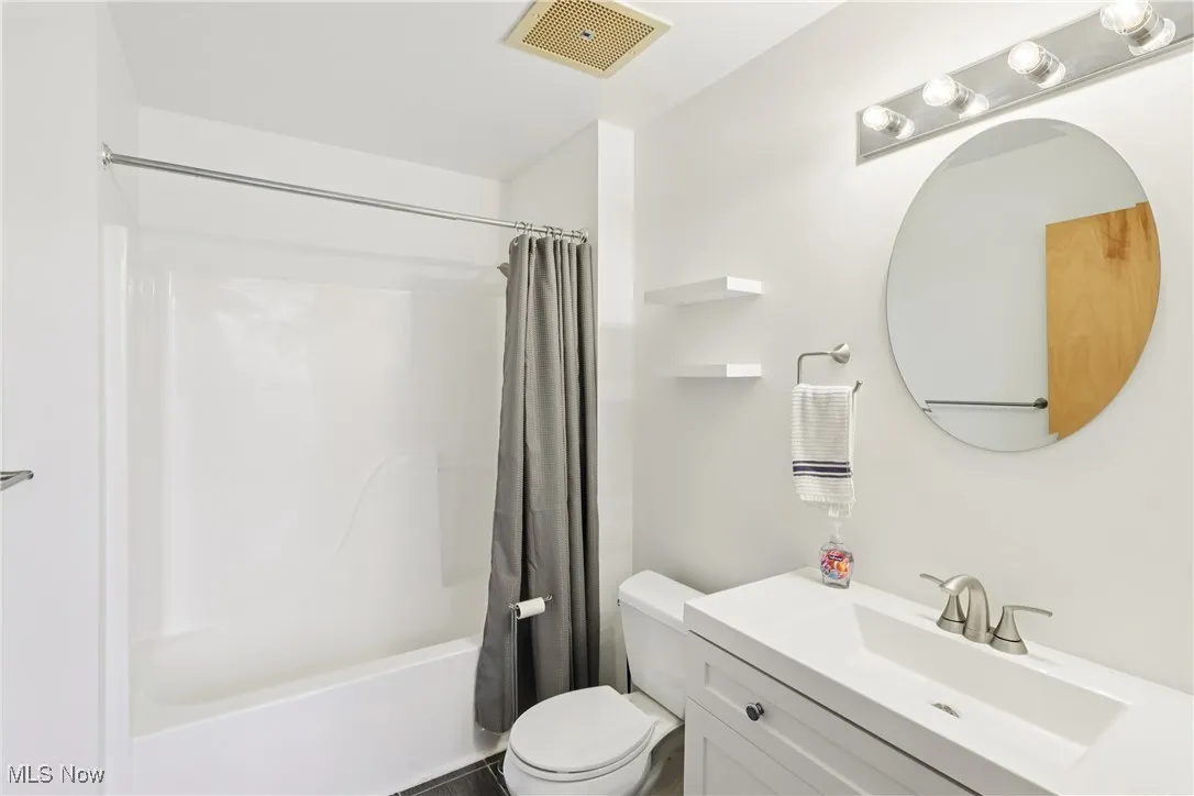 Full bath with shower / bath combo with shower curtain and vanity