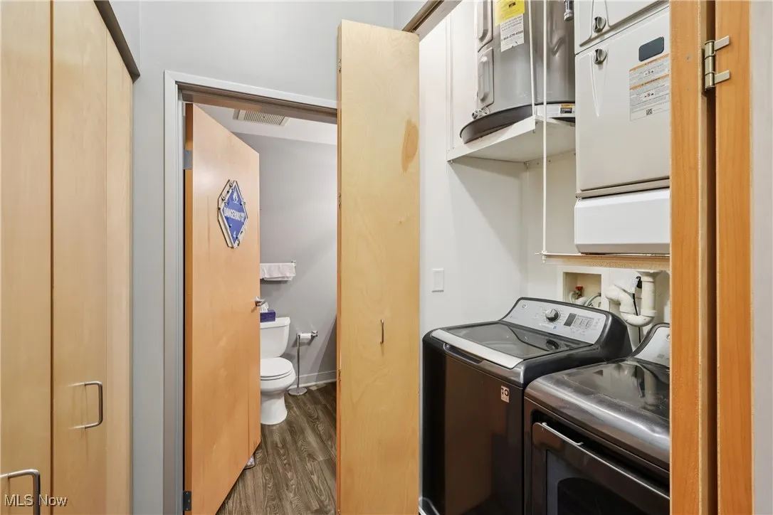Laundry area featuring dark wood-style flooring and washing machine and clothes dryer