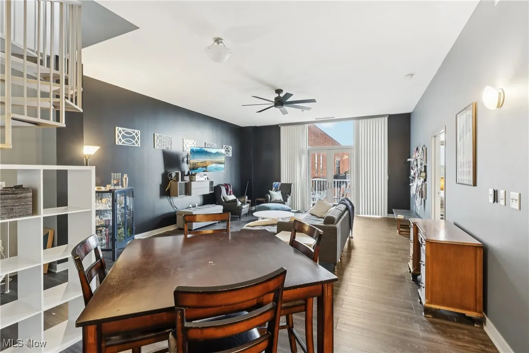 Dining room with dark wood-type flooring, expansive windows, and ceiling fan