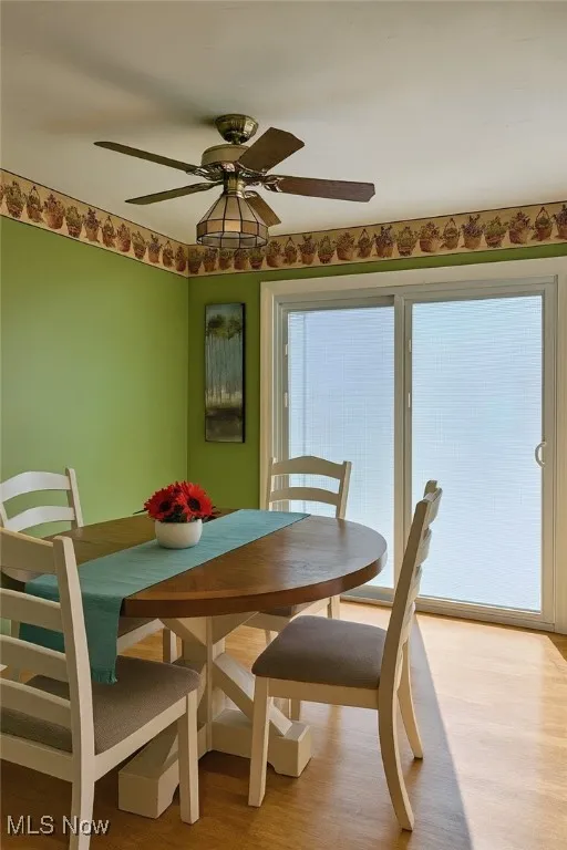 Dining space with wood finished floors and a ceiling fan