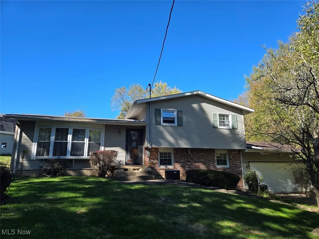 View of front of house with brick siding and a front lawn
