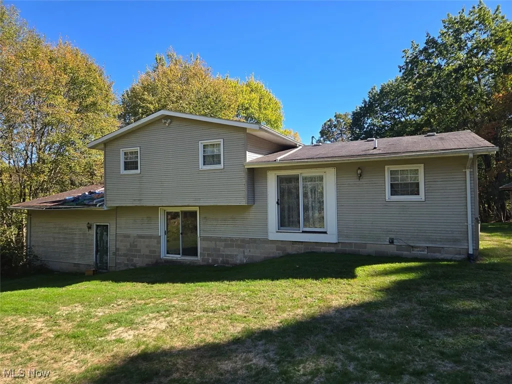 Rear view of property with a lawn