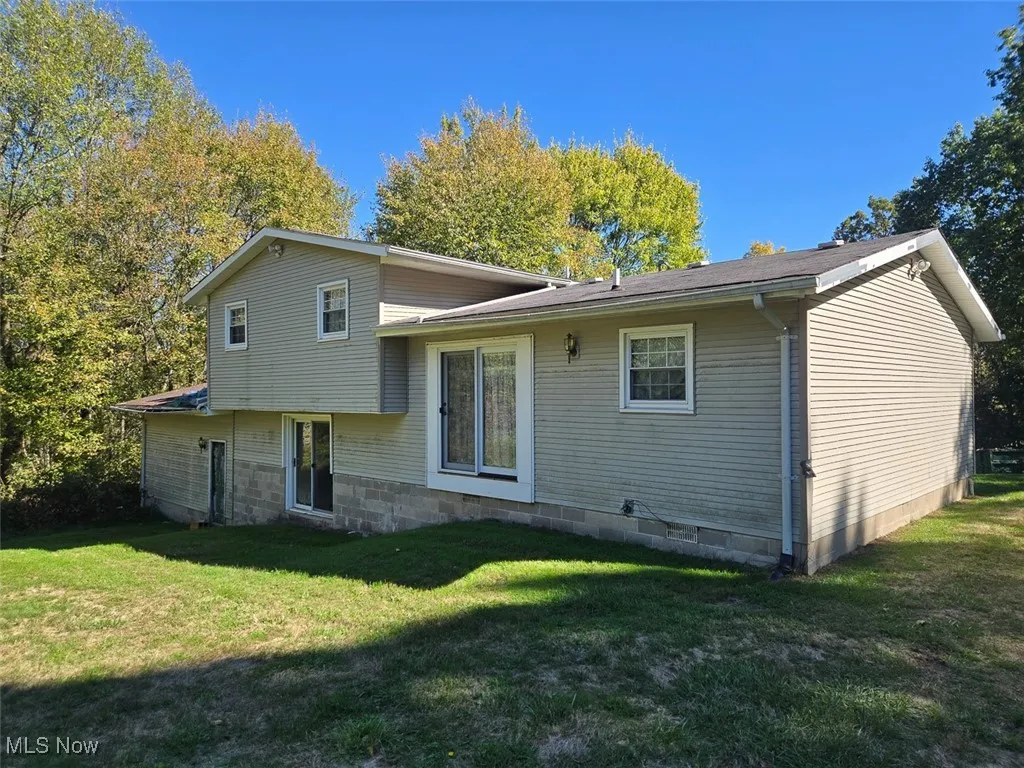 Rear view of house with a lawn