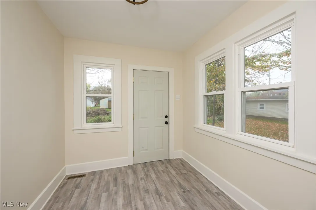 Doorway featuring wood finished floors and baseboards