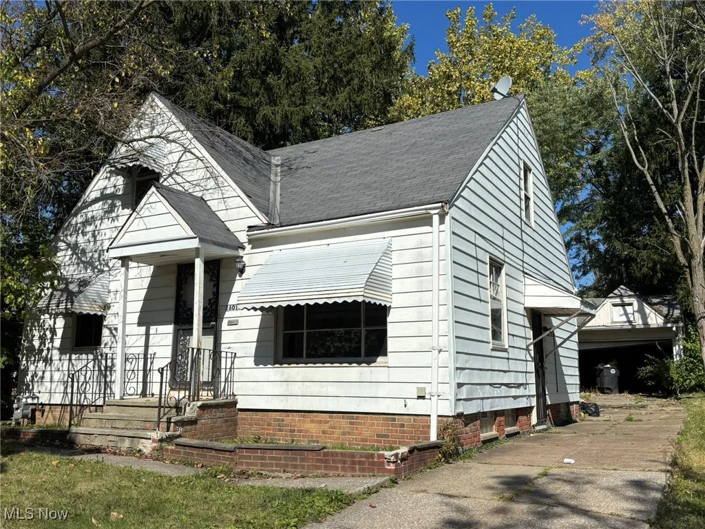 View of front facade featuring roof with shingles and a garage