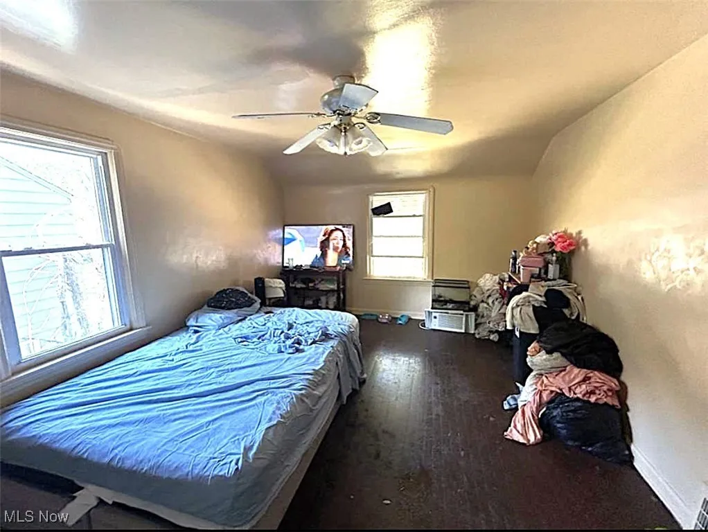 Bedroom with dark wood finished floors, ceiling fan, and lofted ceiling
