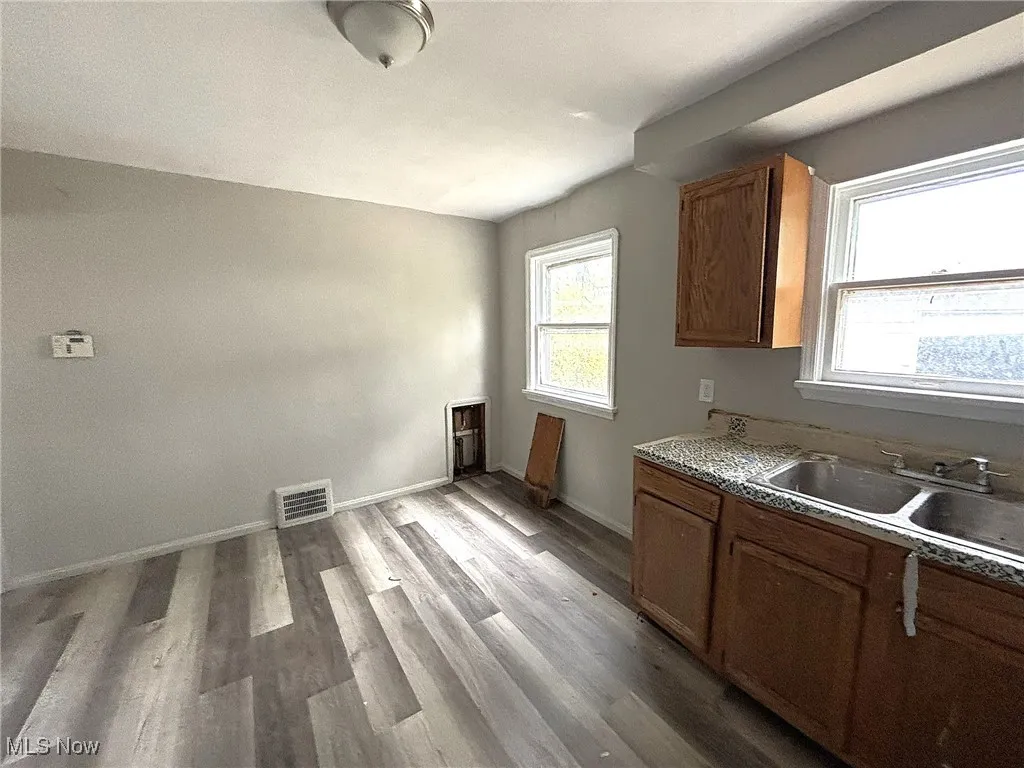 Kitchen featuring dark wood-style floors, brown cabinets, and light countertops