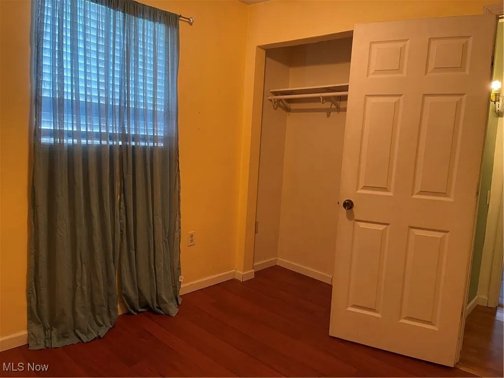 Second bedroom with dark flooring.