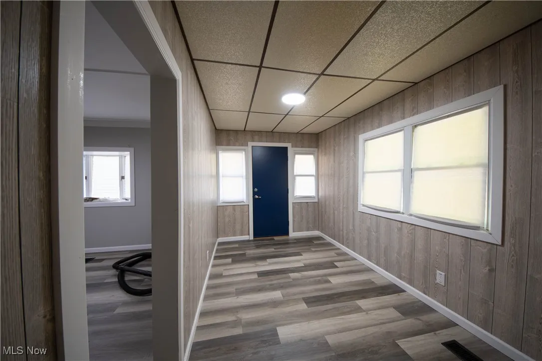 Entryway featuring wood finished floors, healthy amount of natural light, and a paneled ceiling