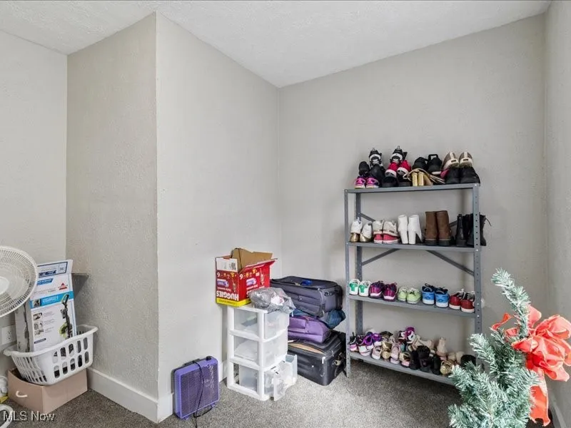 Game room featuring carpet flooring, a textured wall, and a textured ceiling