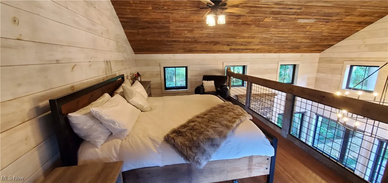 Airy loft bedroom overlooking the cabin and outdoor areas.