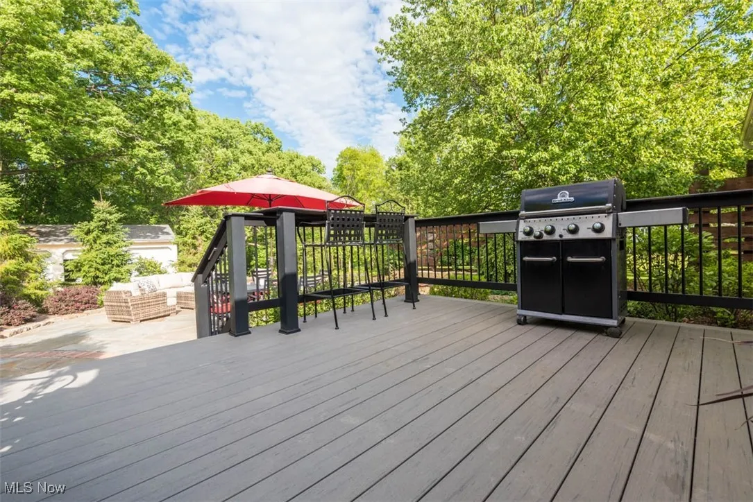 Large deck outfitted for entertaining, complete with seating and a gas grill just steps off the kitchen.