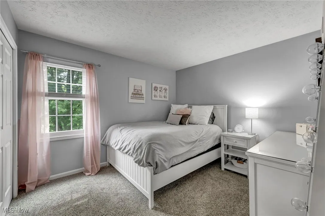 Bedroom featuring light carpet and a textured ceiling