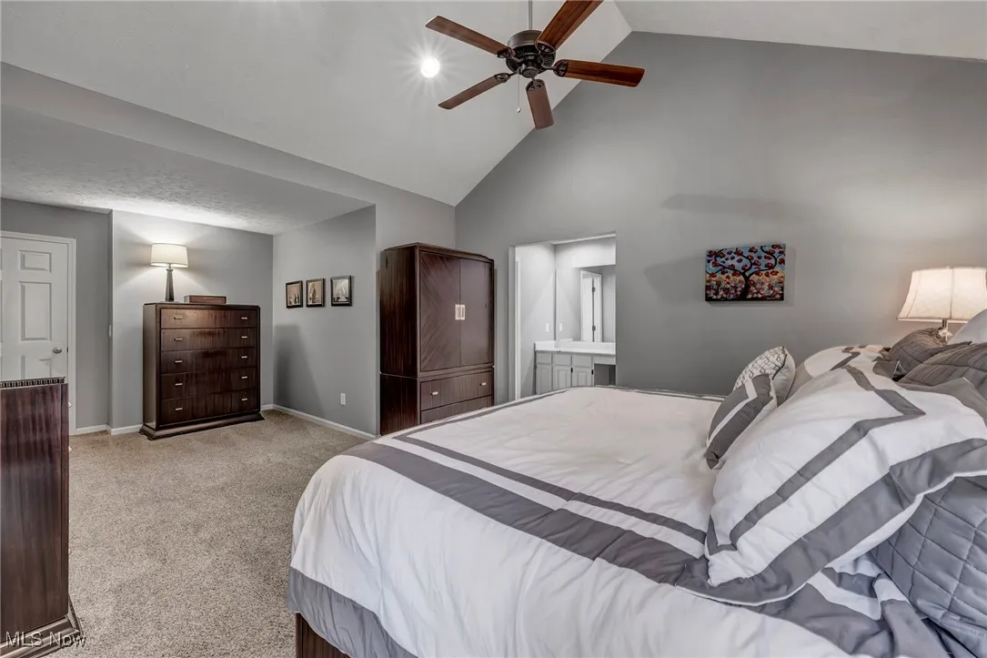Bedroom with high vaulted ceiling, carpet, and ceiling fan