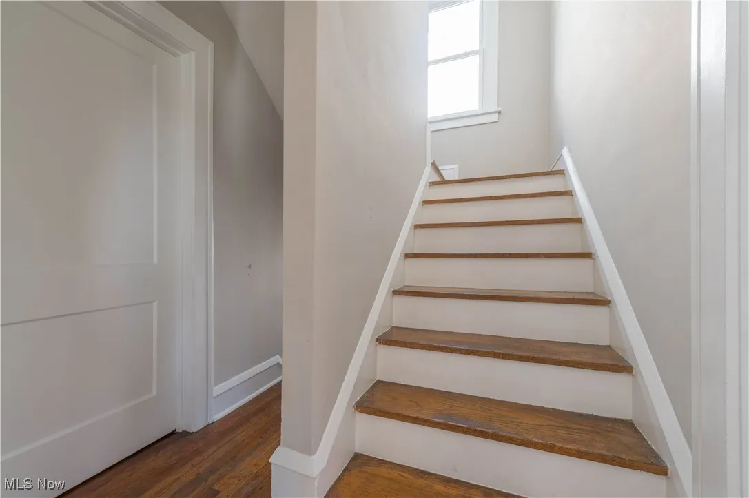 Stairs featuring wood finished floors