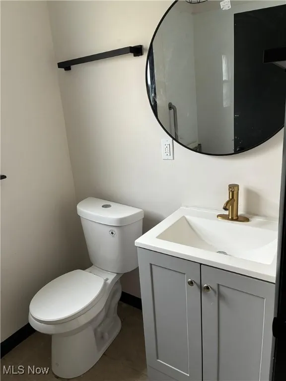 Half bathroom with vanity and tile patterned flooring