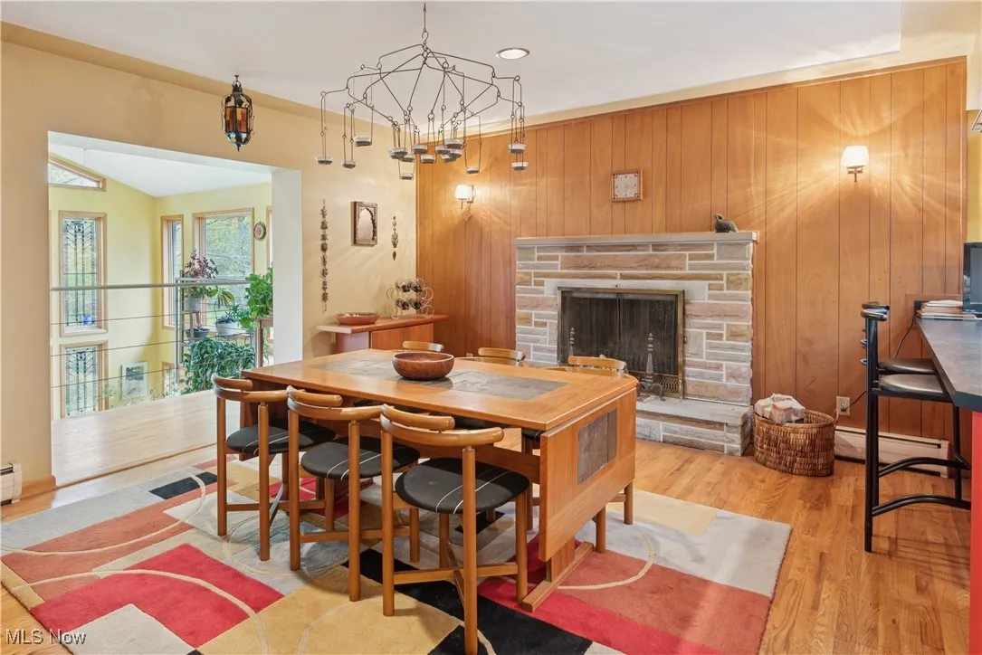 Formal dining area large enough to accommodate your friends and family and dinnerware buffet storage. Featured stunning views into the sunroom and the rear woods and acreage beyond. Wood-burning fireplace with raised hearth. Adjacent breakfast bar and stools for additional seating.