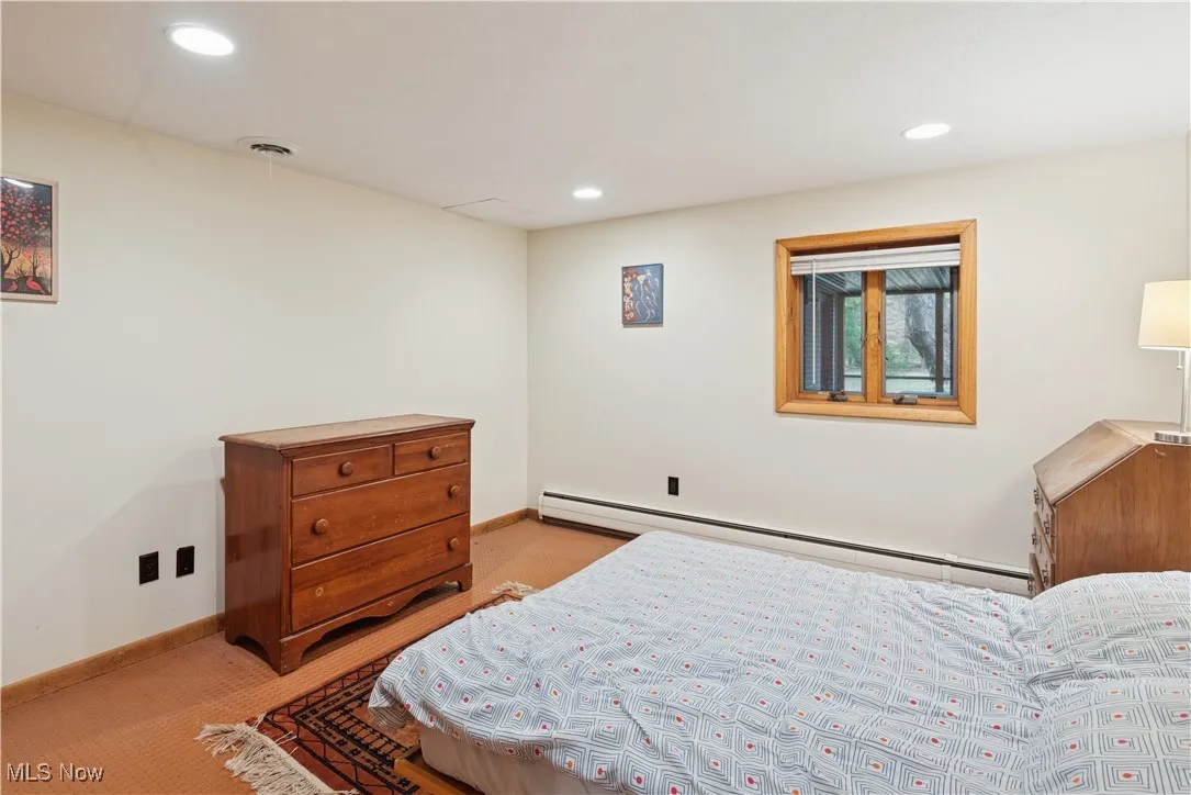 One of two bedrooms on the lower level with a view to the rear yard. Hot water baseboards for heating and ceiling vents for cooling.