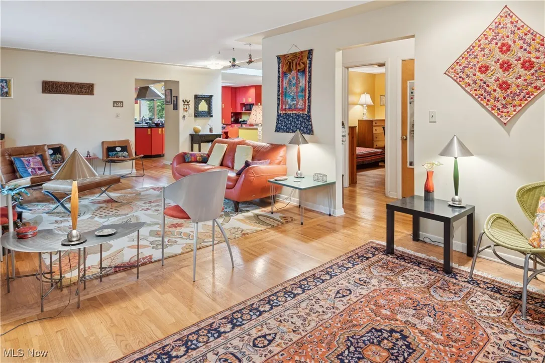 Living room with hardwood floors, a separate hobby/sitting/music area, with view to the eat-in kitchen and the adjacent hallway that leads to two bedrooms/offices and a full bath