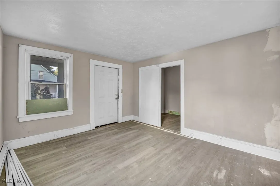 Empty room featuring a textured ceiling and wood finished floors