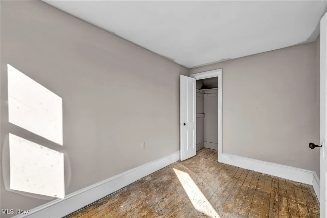 Unfurnished bedroom with hardwood / wood-style flooring and a closet