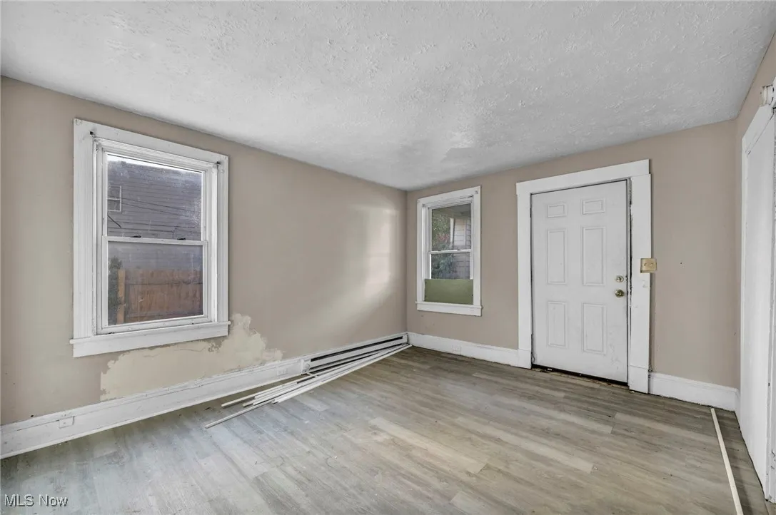 Foyer featuring a textured ceiling, light wood-style floors, and baseboard heating