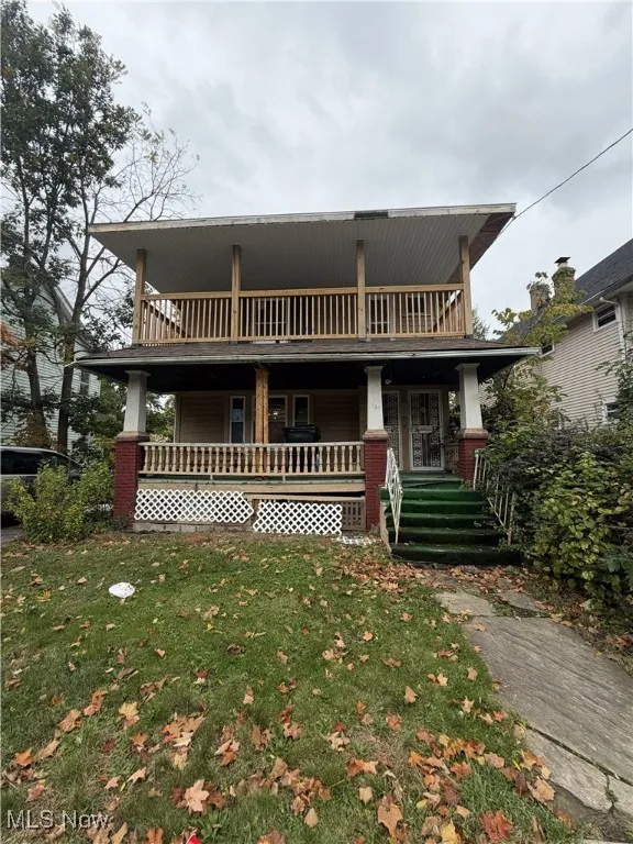 View of front of property with covered porch and a front lawn