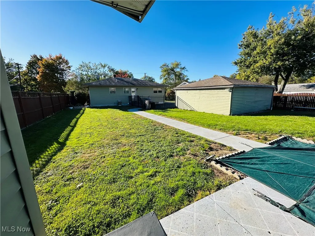 Fenced backyard with an outbuilding