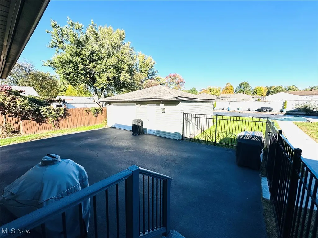 View of patio / terrace with grilling area, an outdoor structure, a residential view, and a garage