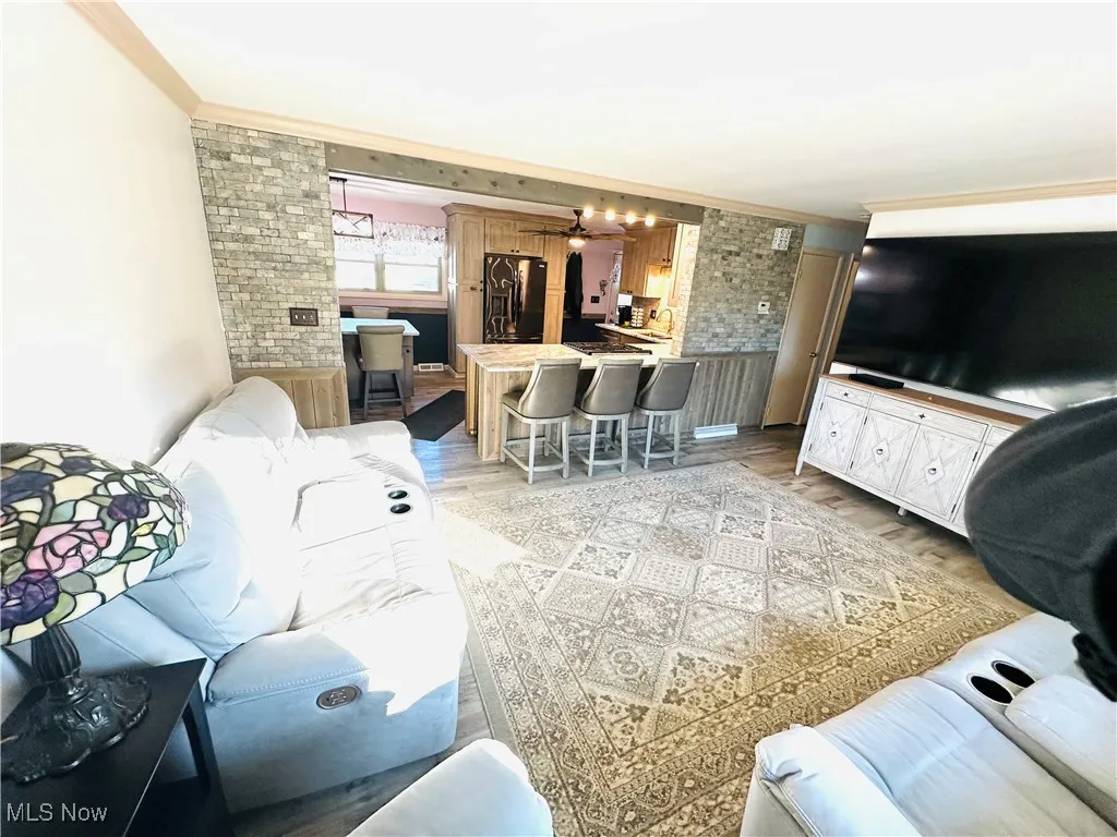 Living area with ornamental molding and light wood finished floors