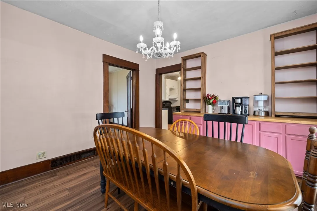 Dining space featuring a chandelier and dark wood-style floors