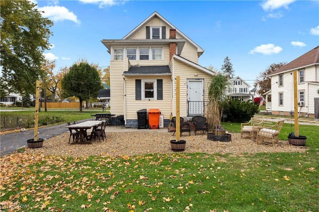 Back of house with a patio area and a yard