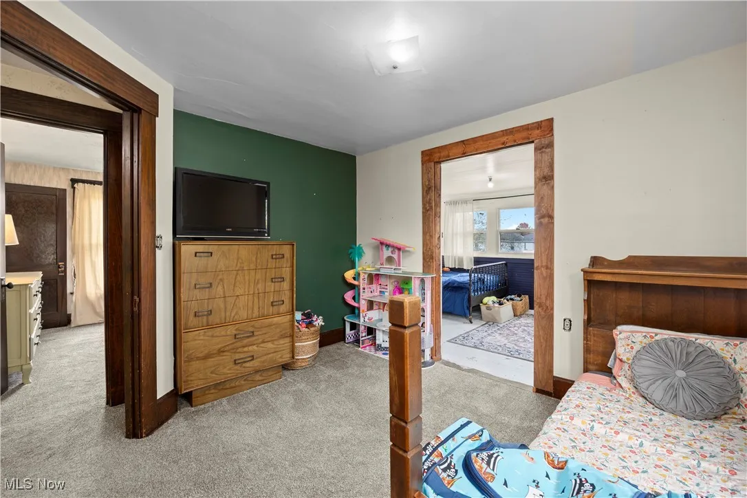 Bedroom featuring light carpet and baseboards