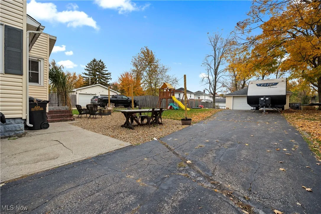 View of yard featuring a playground, an outdoor structure, a patio area, and a garage