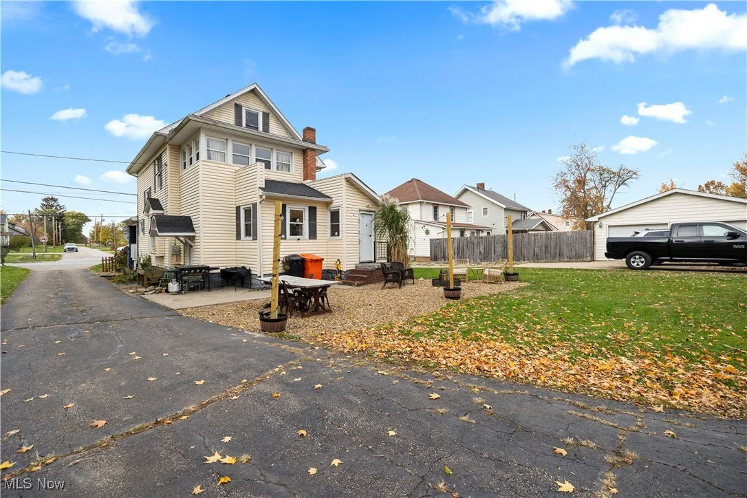 View of front of house with a patio area, a residential view, entry steps, and a chimney