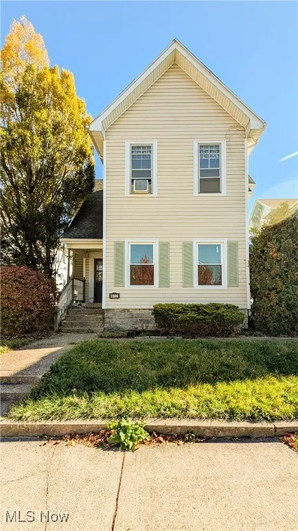 View of front of house with a porch and a front yard